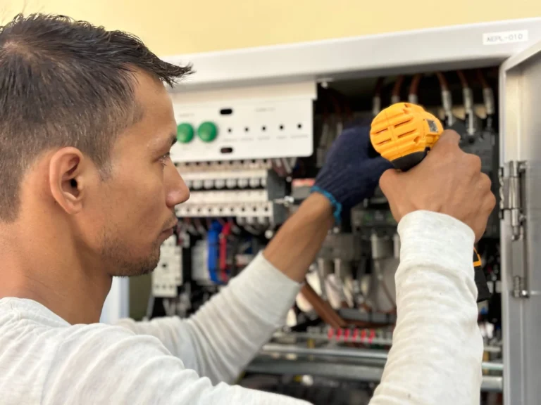 Tecnico ajustando el tablero de control electrico de un cargador