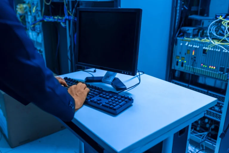 Técnico trabajando en cableado dentro de una sala de servidores