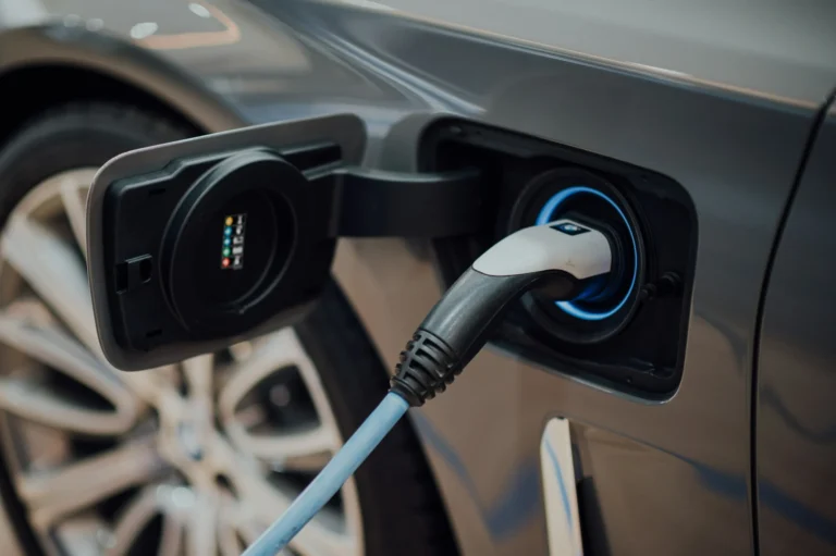 Primer plano del conector de un cargador electrico conectado a un auto