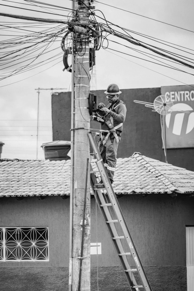 Tecnico trabajando en la caja de conexiones de un cerco electrico sobre poste