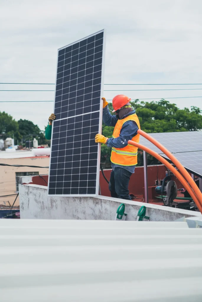Técnico cargando un panel solar en posición vertical para su instalación