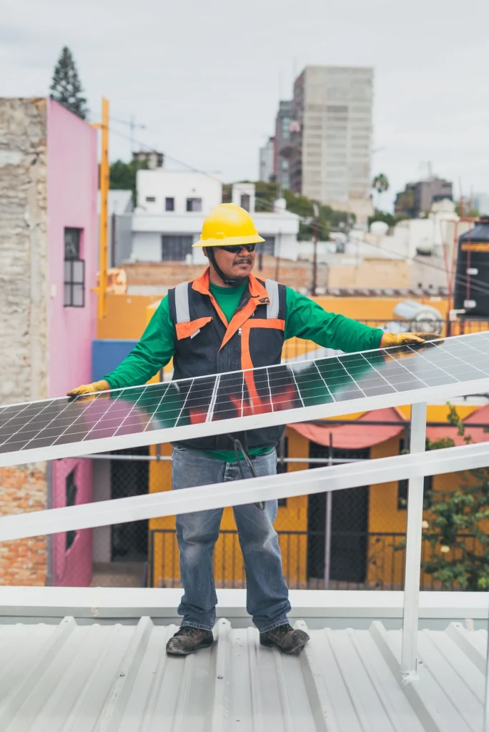 Técnico apoyado junto a un panel solar instalado en el techo