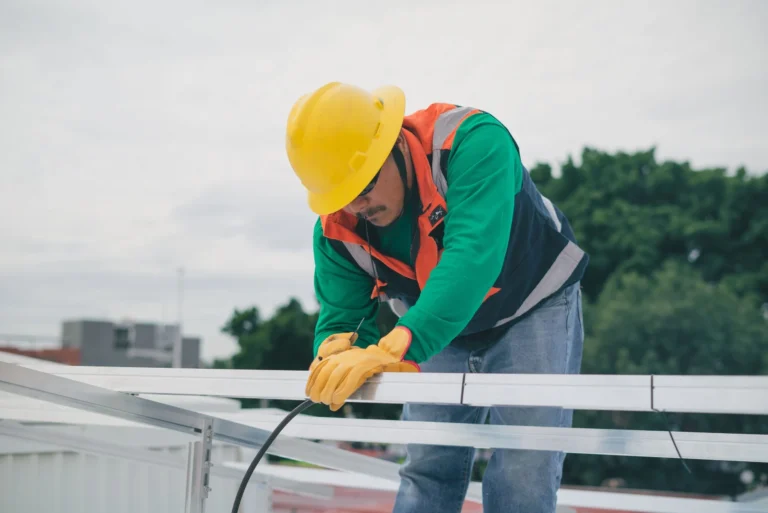 Tecnico asegurando las conexiones de un panel solar recien instalado