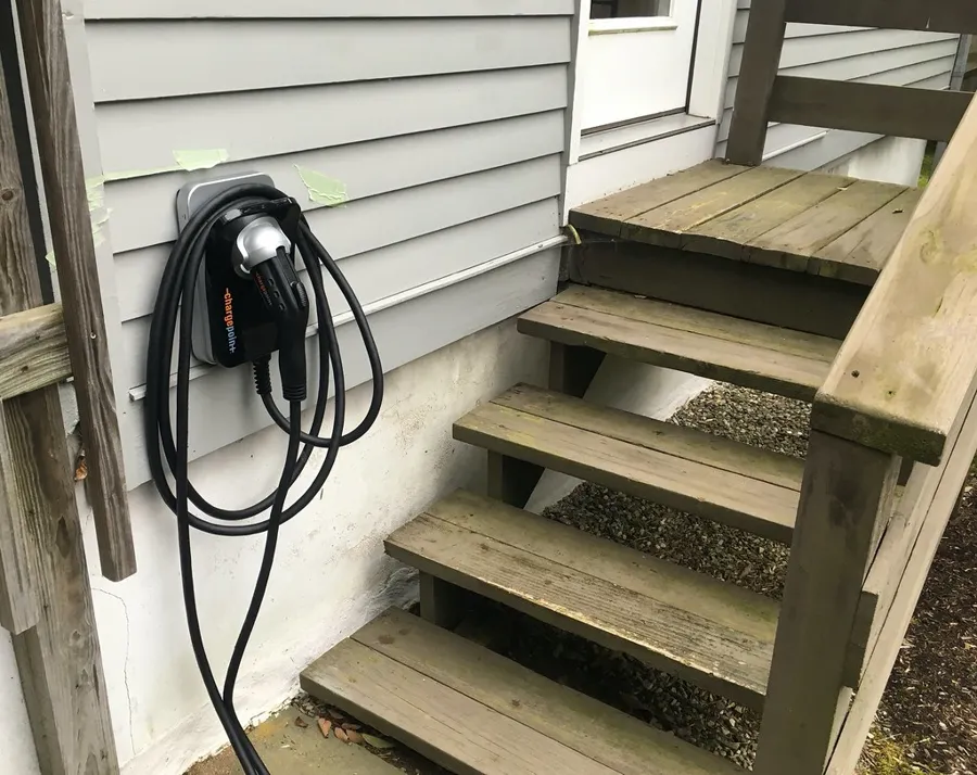 Cargador de pared para auto eléctrico instalado en la fachada de una casa