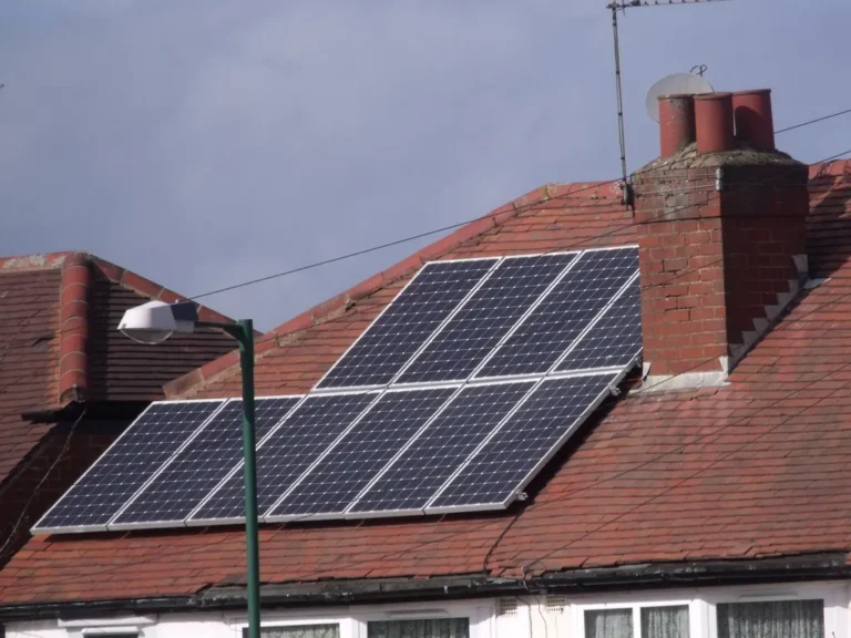 Casa con techo de teja roja y paneles solares instalados en dos niveles