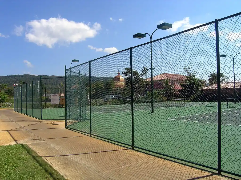 Canchas de tenis rodeadas por malla ciclónica alta de color verde
