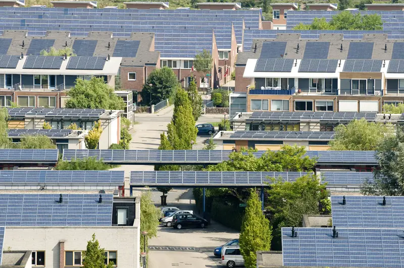 Hileras de casas con paneles solares en techos de distinta forma y orientación