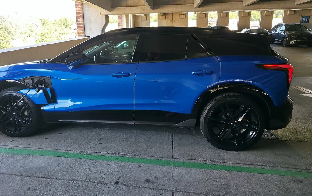 Camioneta eléctrica conectada a un cargador en un estacionamiento techado