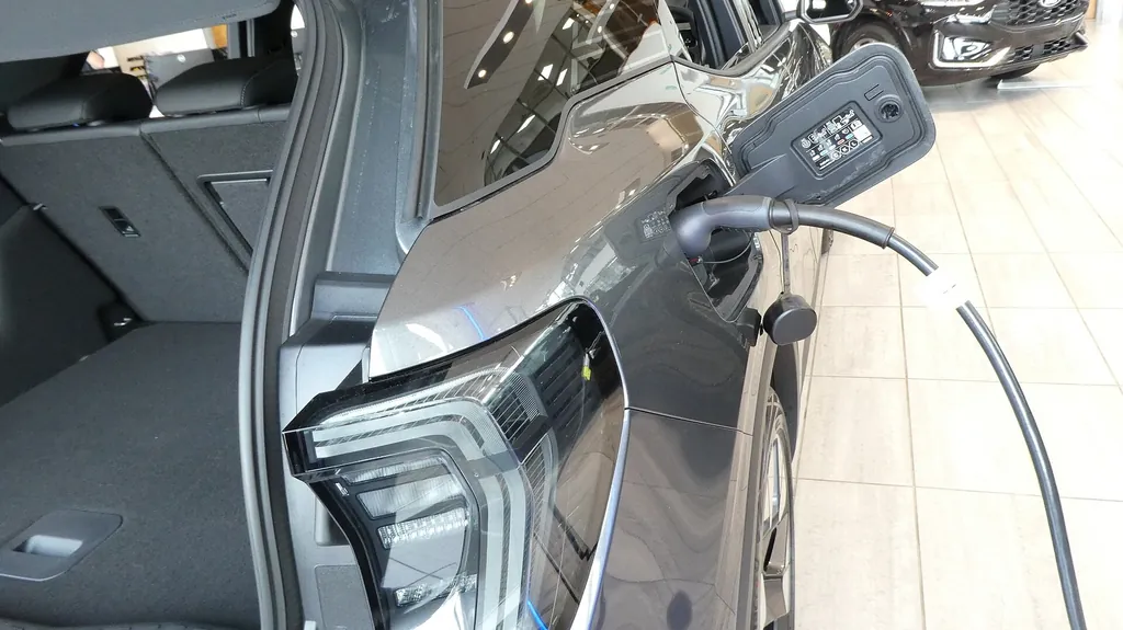 Camioneta eléctrica gris conectada a un cable de carga tipo 2