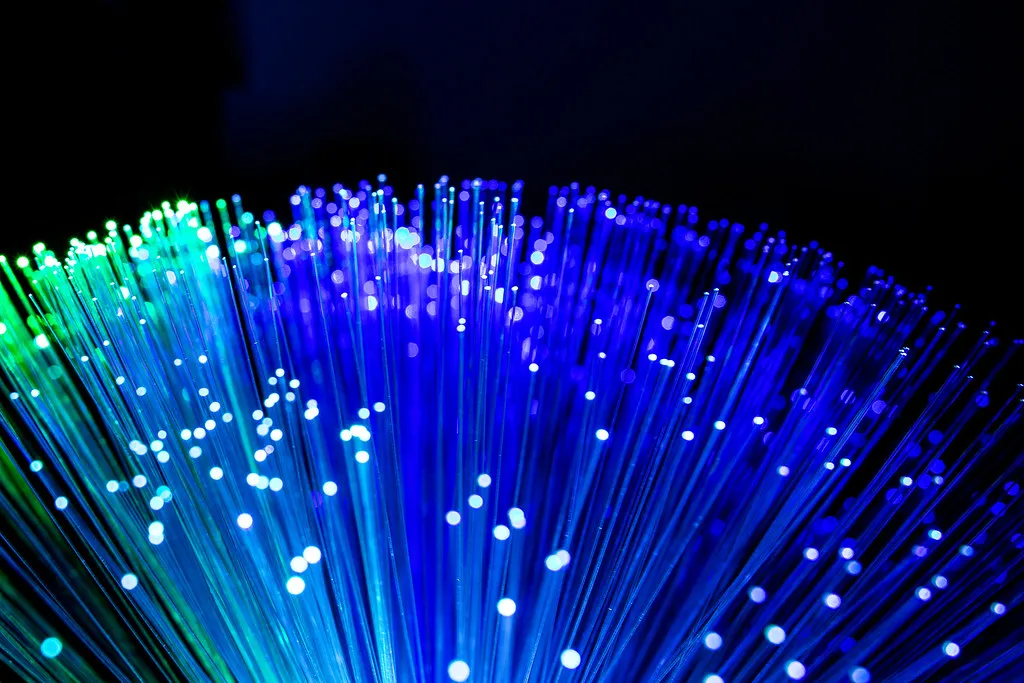 Puntas de muchos hilos de fibra óptica iluminadas en azul