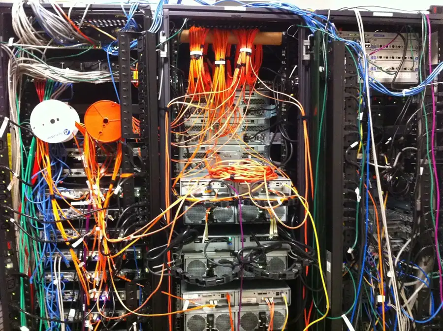 Racks de red con cables de muchos colores enredados sin organizadores